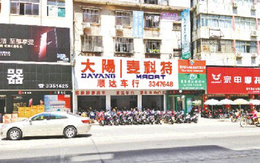 穿馬甲的助力車被作為重點推銷的產品擺放在店門口